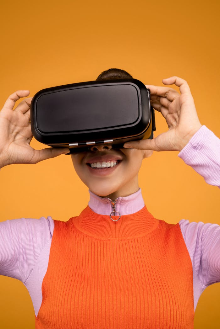 Smiling woman wearing VR headset on vibrant orange background.